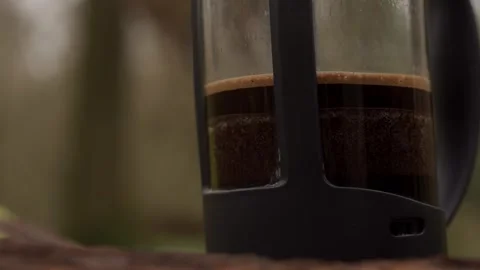 Making coffee outdoors by pressing down coffee grounds with a filter Video stock 260826412