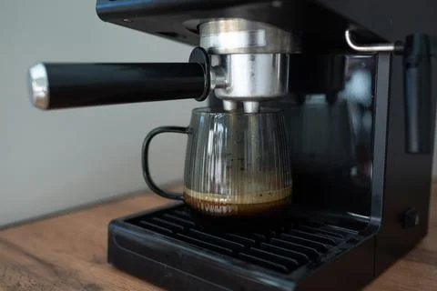 Making coffee using a modern espresso machine on a wooden table on a light Stock Photos