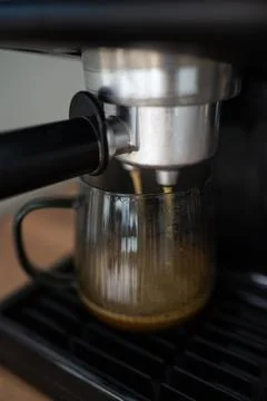 Making coffee using a modern espresso machine on a wooden table on a light Stock Photos
