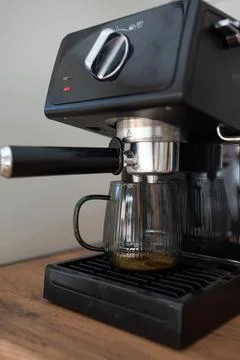 Making coffee using a modern espresso machine on a wooden table on a light Stock Photos