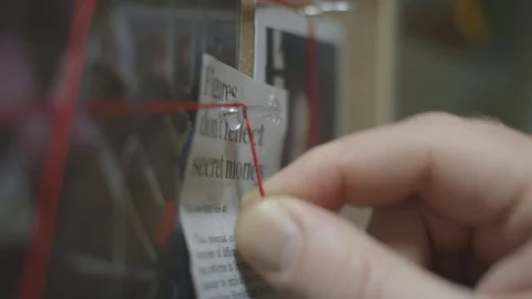 Making connections in the mystery, tying string from clue to clue Stock Footage