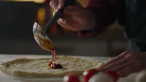 Making, Cook Cooking Baking Professionally Adds Red Tomato Sauce to Dough at Stock Footage 242530037