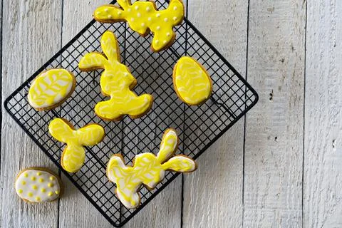 Making cookies for Easter. Bunny and eggs decorated with icing dry on the wir Stock Photos