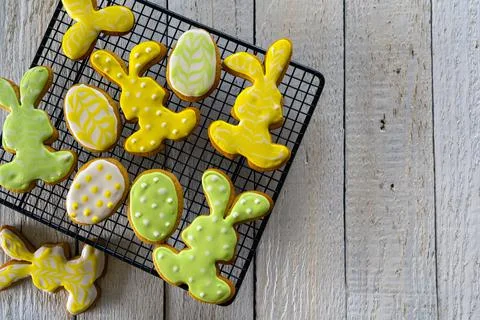 Making cookies for Easter. Bunny and eggs decorated with icing dry on the wir Stock Photos