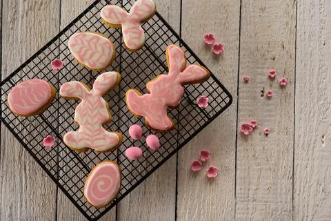 Making cookies for Easter. Bunny and eggs decorated with icing dry on the wir Stock Photos