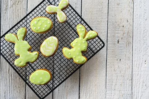 Making cookies for Easter. Bunny and eggs decorated with icing dry on the wir Stock Photos
