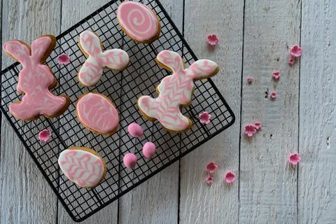Making cookies for Easter. Bunny and eggs decorated with icing dry on the wir Stock Photos