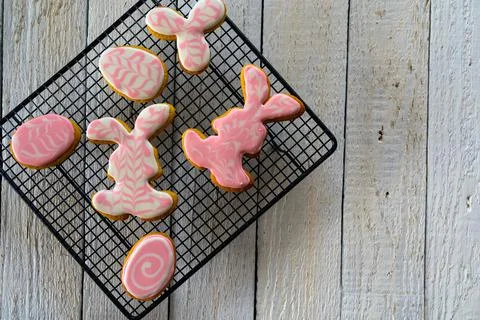 Making cookies for Easter. Bunny and eggs decorated with icing dry on the wir Stock Photos