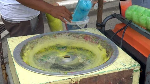 Making of Cotton Candy. Working man making sugar cotton candy during holiday  Stock-Footage 99919223