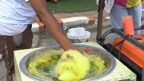 Making of Cotton Candy. Working man making sugar cotton candy during holiday  Stock-Footage 99919225