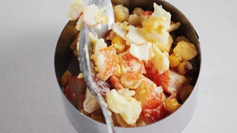 Making crab salad with cheese, canned corn and eggs. Close-up of putting with Stock Footage 307486151