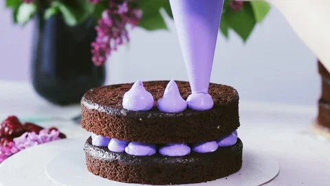 Making cream cones on the chocolate cake using pastry bag Stock Footage 102042577