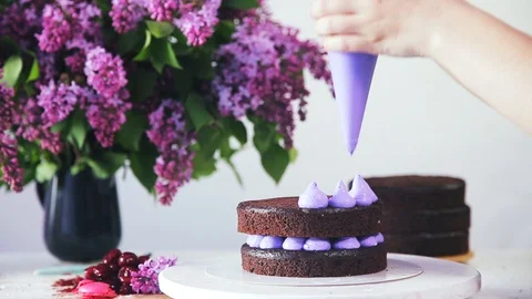 Making cream cones filling using pastry bag on the chocolate cake layers. Stock Footage 102042559