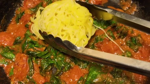 Making a creamy tomato and spinach Angel Hair Pasta in a frying pan Stockbeeldmateriaal 341616759