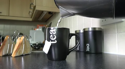 Making a cup of tea with a tea bag on kitchen worktop Stock Footage 67278333