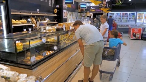 Making decision which products to choose buy. Father driving sons in shopping Stock Footage 113301467