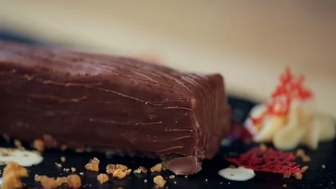 Making decoration of dessert. Put a piece of honey crumb on piece of chocolate. Vidéo 75417050