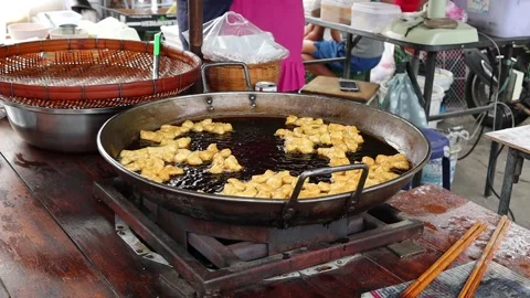 Making deep fried dough stick in metal pan and hot oil Stock Footage 140869327