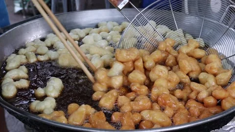 Making deep fried dough stick in metal pan and hot oil Stock Footage 141306534