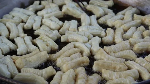 Making deep fried dough stick in metal pan and hot oil Stock Footage 141307242