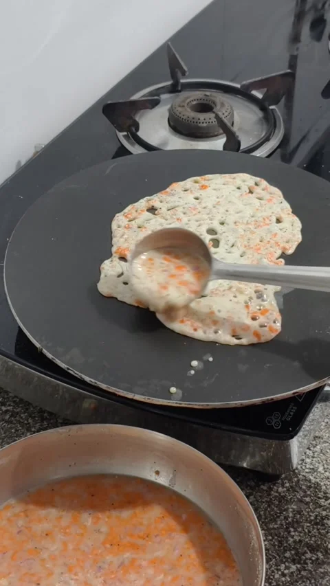 Making delicious rawa - semolina and rice flour dosa with carrots and onions Stock Footage 312804255