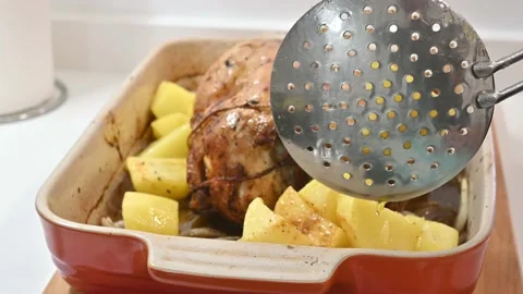 Making a delicious roast chicken. Adding the potatoes Stock Footage 217984017