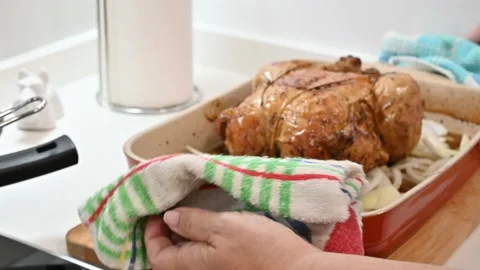 Making a delicious roast chicken. Put it back in the oven Stock Footage 217983908