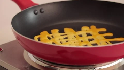 Making different figures in a cooking pan with scrambled eggs for a omelette Stock Footage 133814180