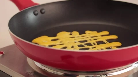 Making different figures in a cooking pan with scrambled eggs for a omelette Stock Footage 133814601