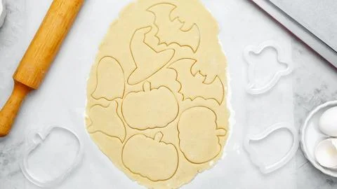 Making different shapes of fall cookies for Halloween. Dough with cookie cutt Stock Photos