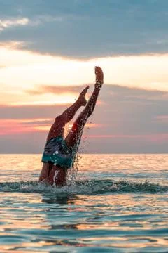 Making a dive into the water at the beach. Stock Photos