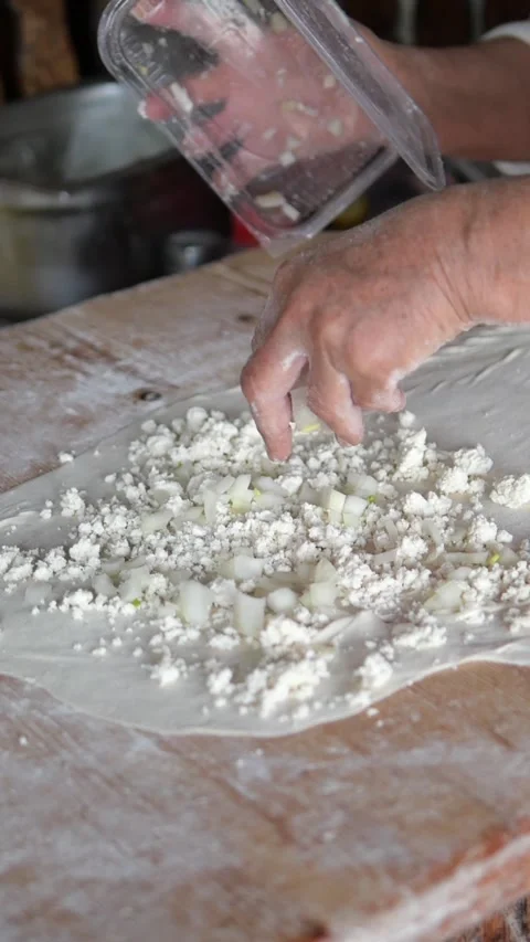 Making dough with cheese and onions at the kitchen table Stock Footage 340178413