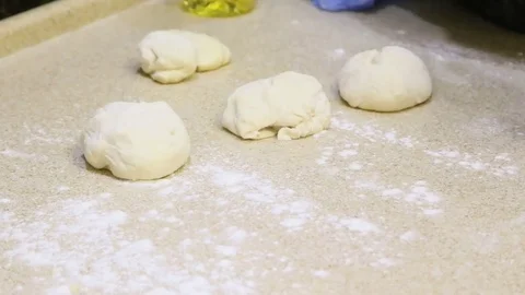 Making dough. Human hands roll out pieces on light table Stock Footage 72509915