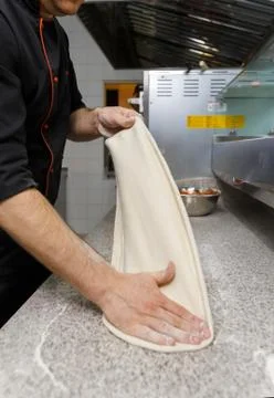 Making dough by male hands on table background.  Pizza maker prepares a pizza Fotos Stock