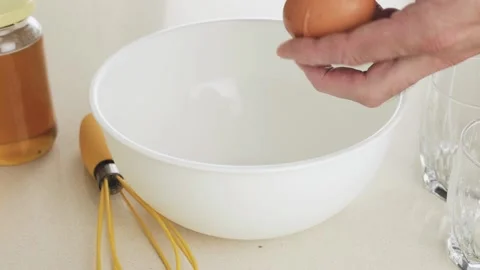 Making dough for pancakes - break an egg into a white plastic bowl 動画素材 147171642