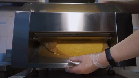 Making dough sheets. Rolled dough in a special culinary machine. Stock Footage 125956327