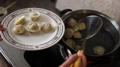 Making dumplings and cooking dumplings at home for Chinese New Year Stock Footage 229998216