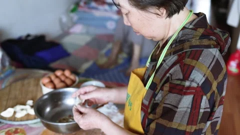 Making dumplings from scratch - putting raw meat into the dumpling wrapper Stock Footage 310040702