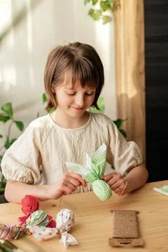 Making Easter decorations. A girl makes a textile Easter egg at home in the Stock Photos