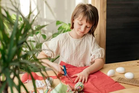Making Easter eggs in the shape of a hare from textile. The girl prepares the Stock Photos