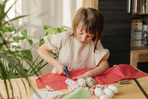 Making Easter eggs in the shape of a hare from textile. The girl prepares the Stock Photos