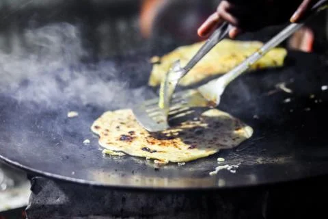 Making of egg roll on a hot frying pan with oil and paratha and salad Foto stock