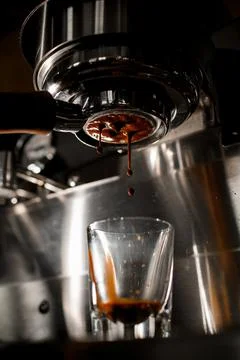 Making espresso on coffee machine through holder from arabica coffee Stock Photos