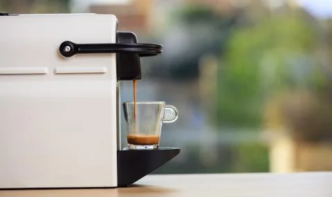 Making espresso. Espresso coffee maker on a wooden table. Blurred background, Stock Photos