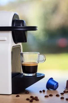 Making espresso. Espresso coffee maker on a wooden table. Blurred green backg Stock-Fotos