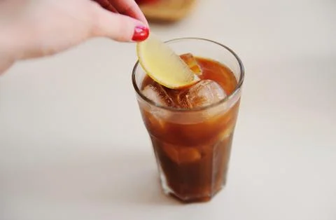 Making espresso tonic. Adding a lemon slice into espresso tonic Stock Photos