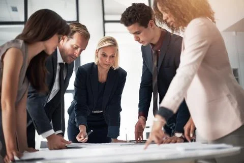 Making a few minor changes to their plans. a team of professionals working on Stock Photos