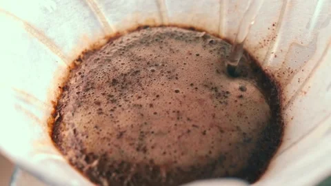 Making Filter Coffee. Water is poured thin stream circular motion into Ground Stock Footage 169411935