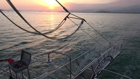 Making fire for grill on a moving boat at sunset Stock Footage 112278802