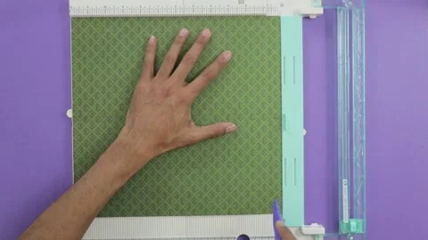 Making folds of green pattern paper with craft board tool, purple Stock Footage 279990871